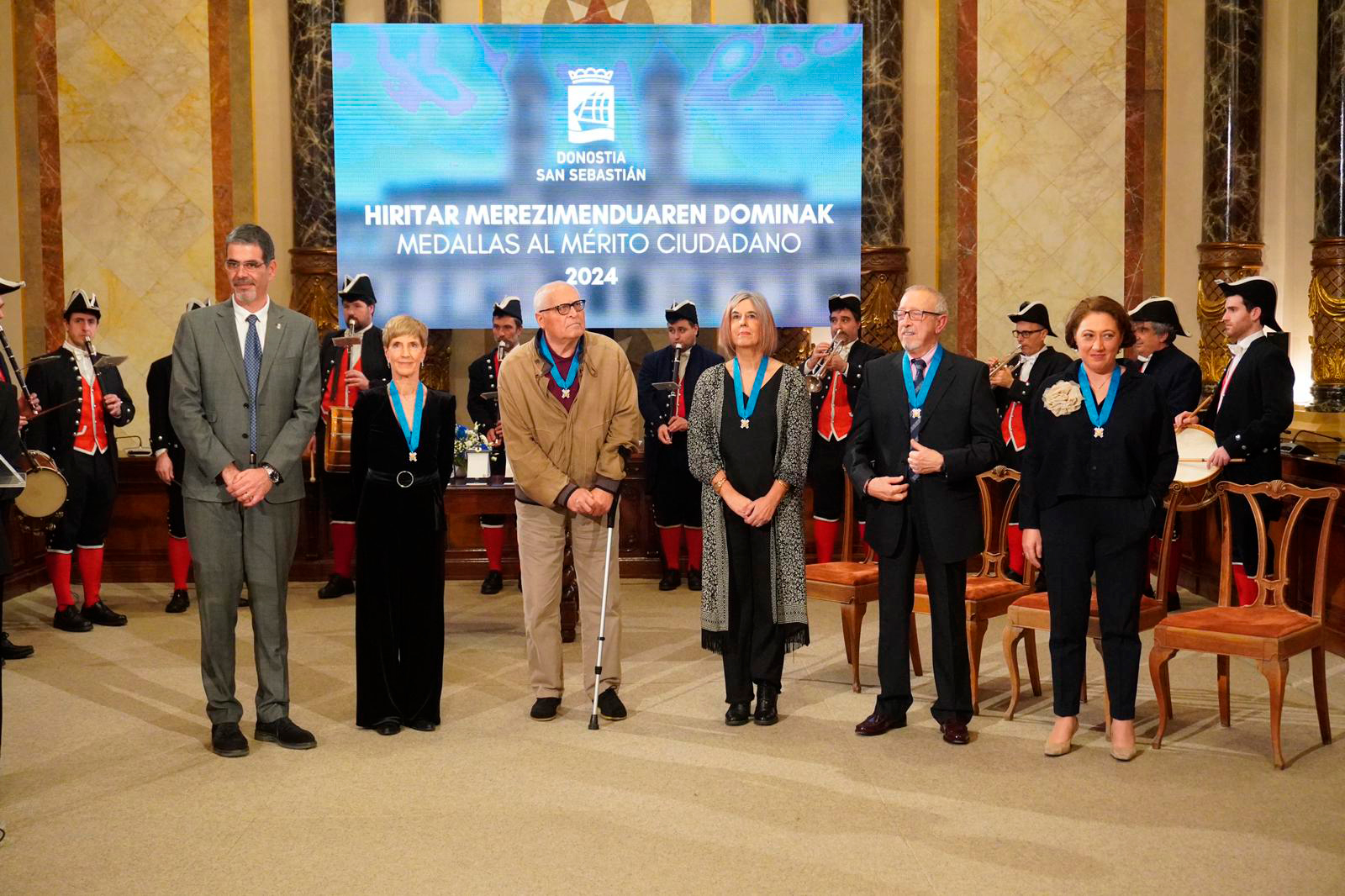 5 personas con la medalla al mérito ciudadano junto al alcalde, de pie
