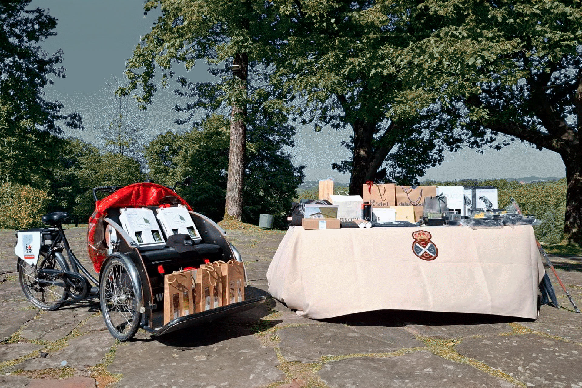 Triciclo de BAE junto a una mesa llena de regalos, en medio de un campo de golf