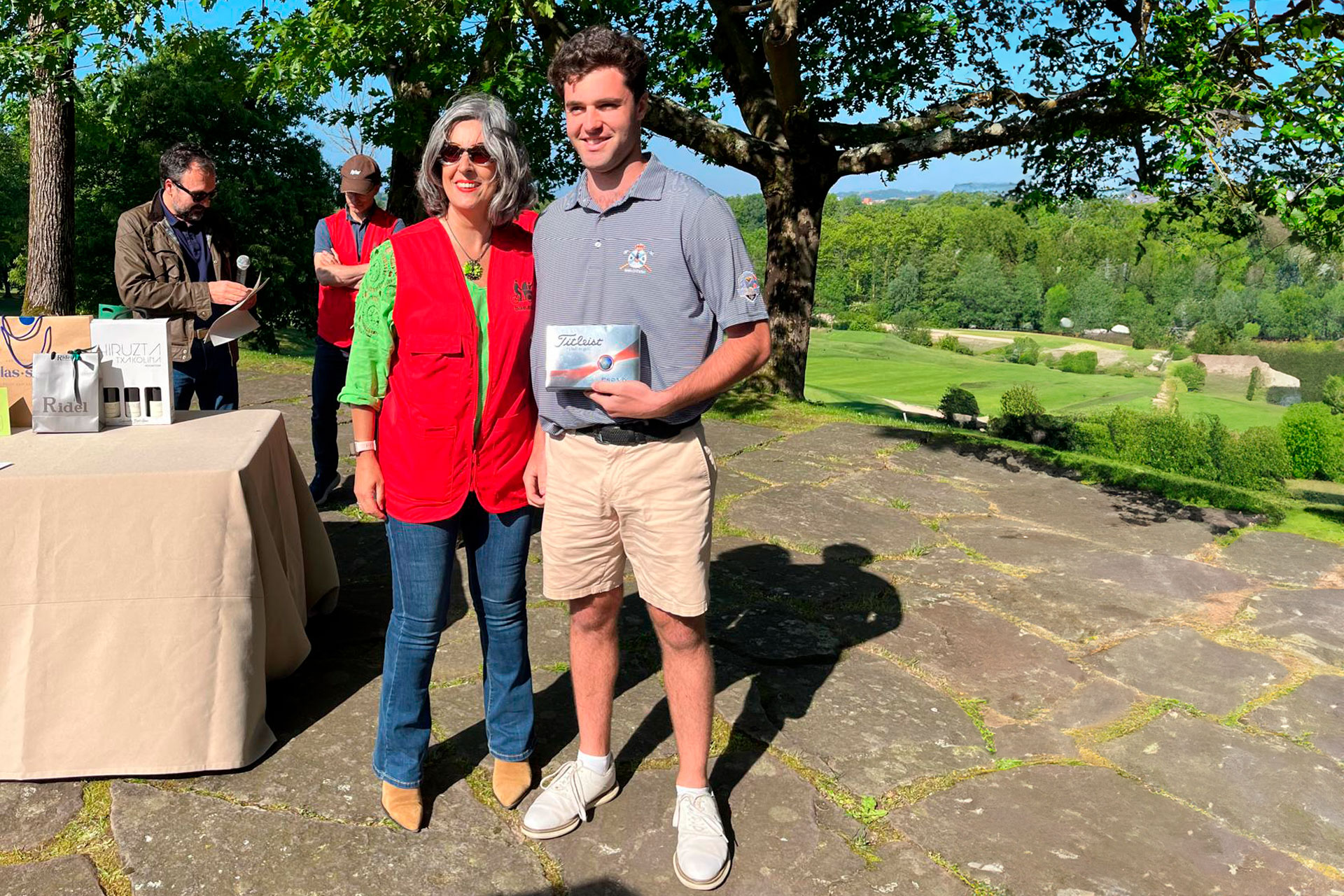 Dos personas, una de ellas con un premio en la mano