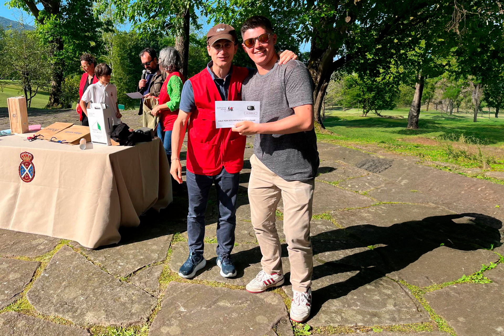 Dos personas, una de ellas con un premio en la mano