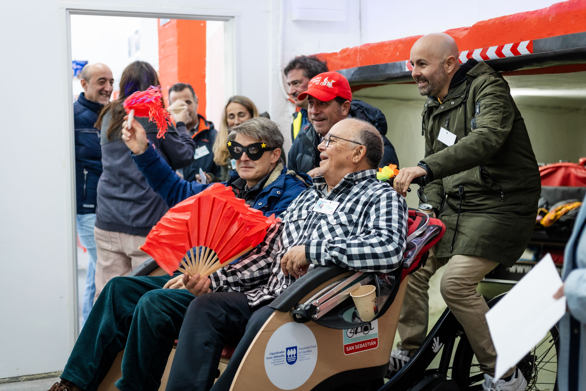 Dos personas en un riciclo disfrazadas, con gente alrededor
