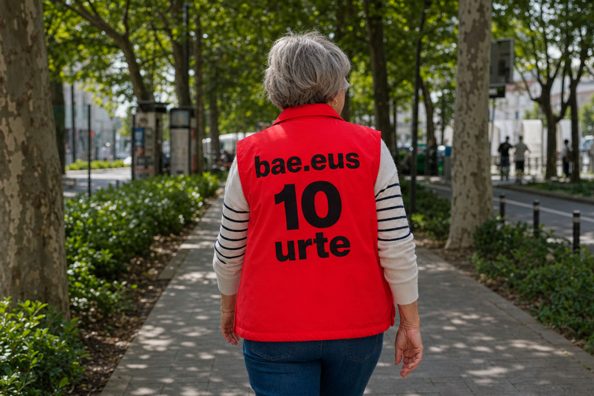 Mujer paseando por la ciudad con un chaleco rojo donde en la espalda pone 10 urte